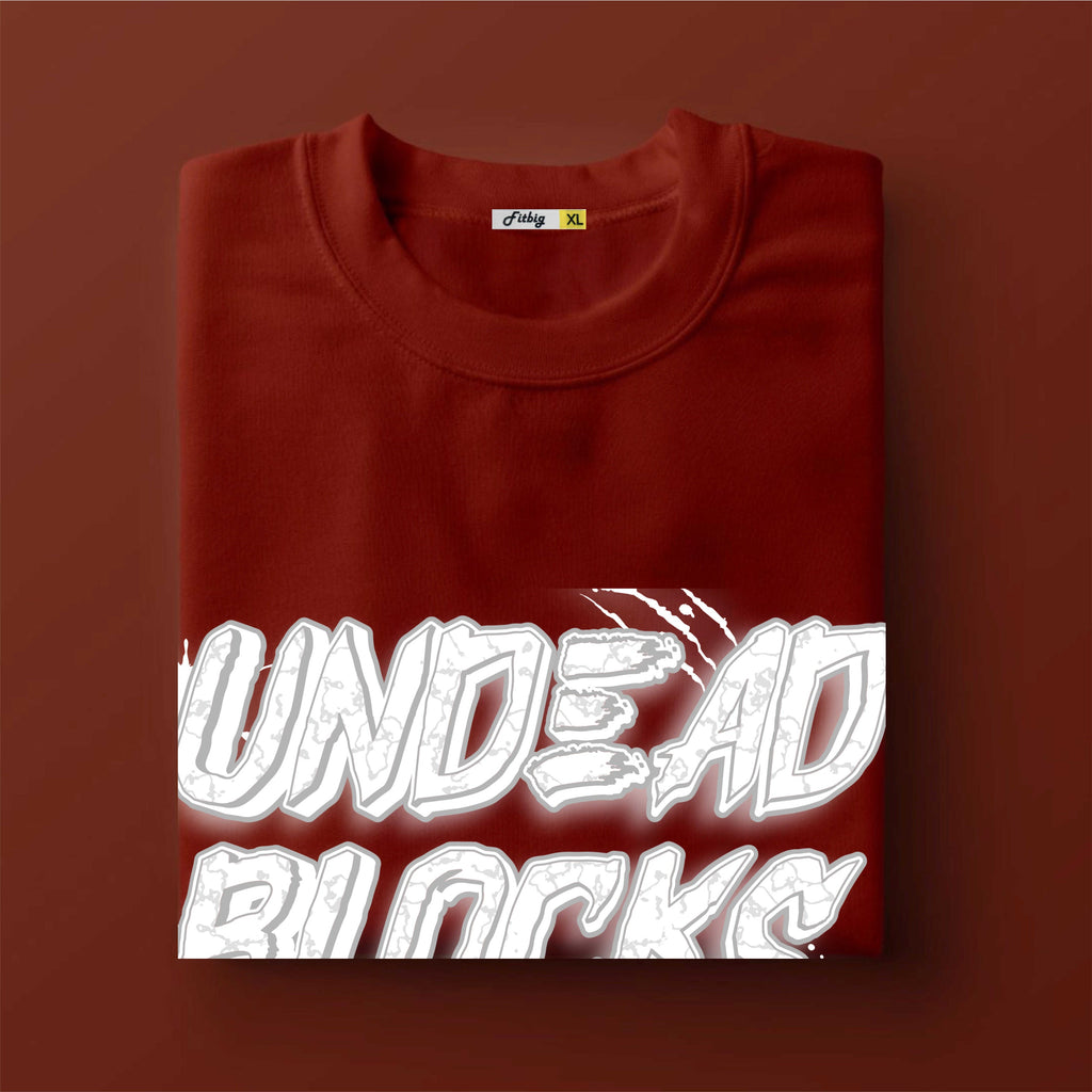 Folded red sweatshirt with 'UNDEAD BLOCKS' text on a brown background