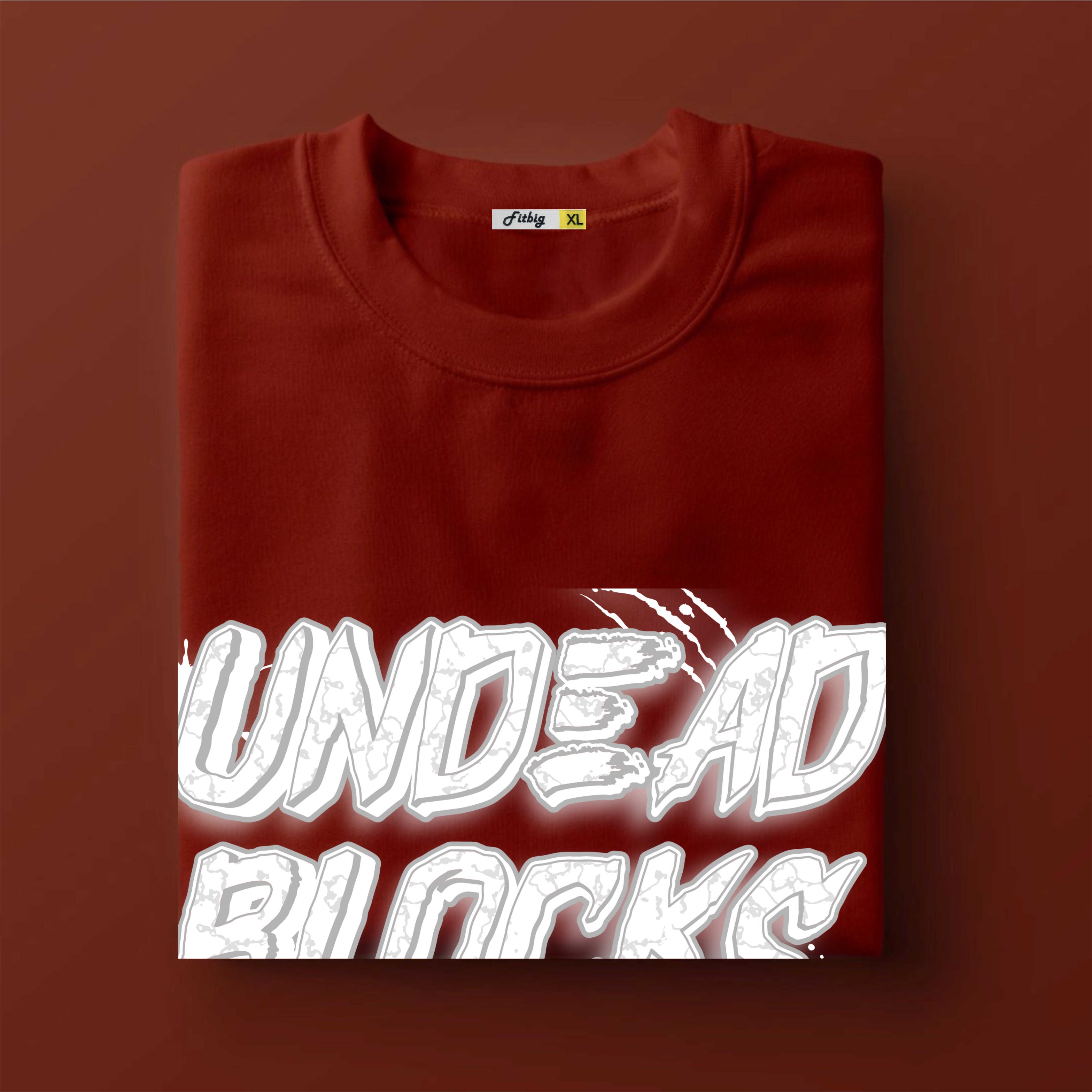 Folded red sweatshirt with 'UNDEAD BLOCKS' text on a brown background