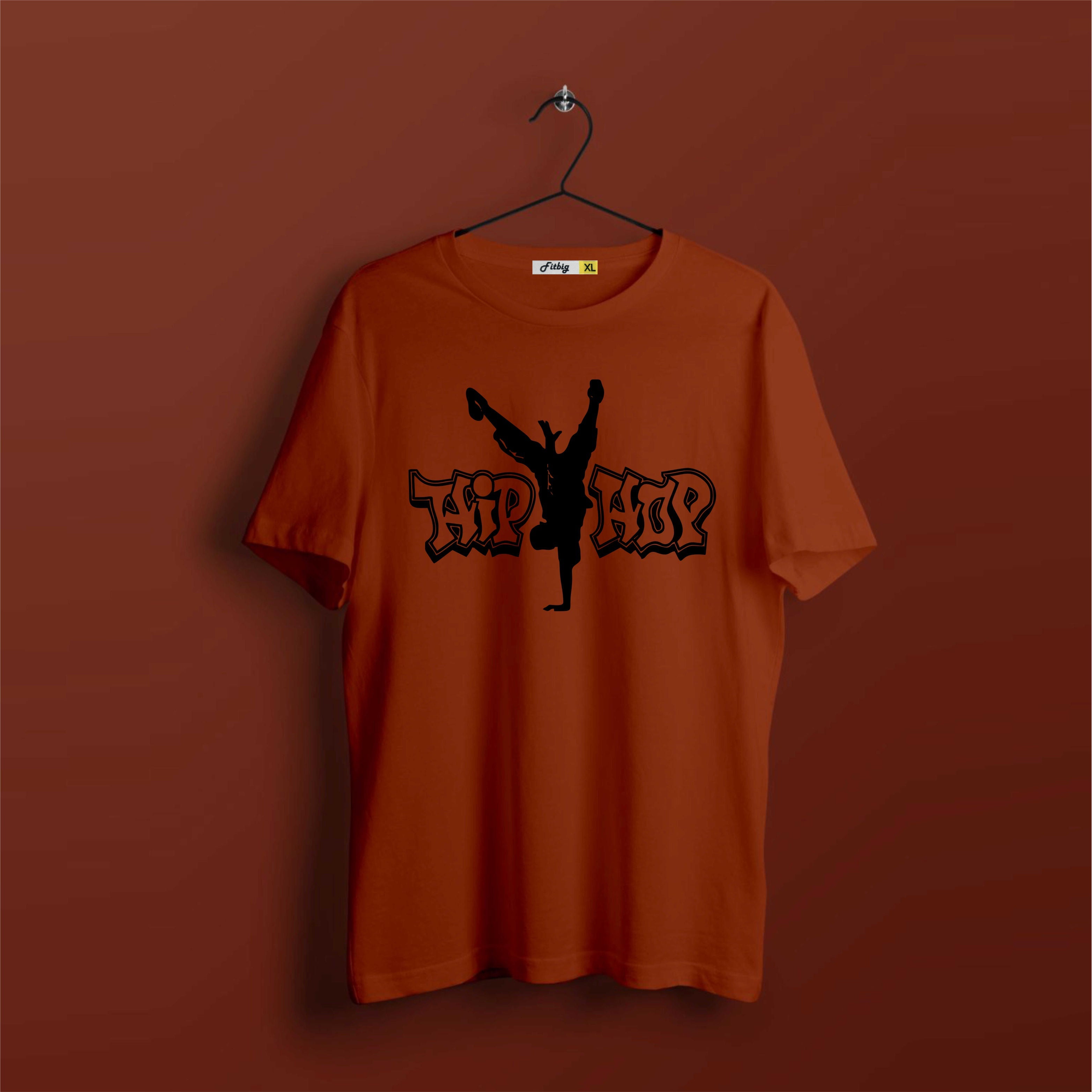 Orange t-shirt with black graphic design on a hanger against a brown background