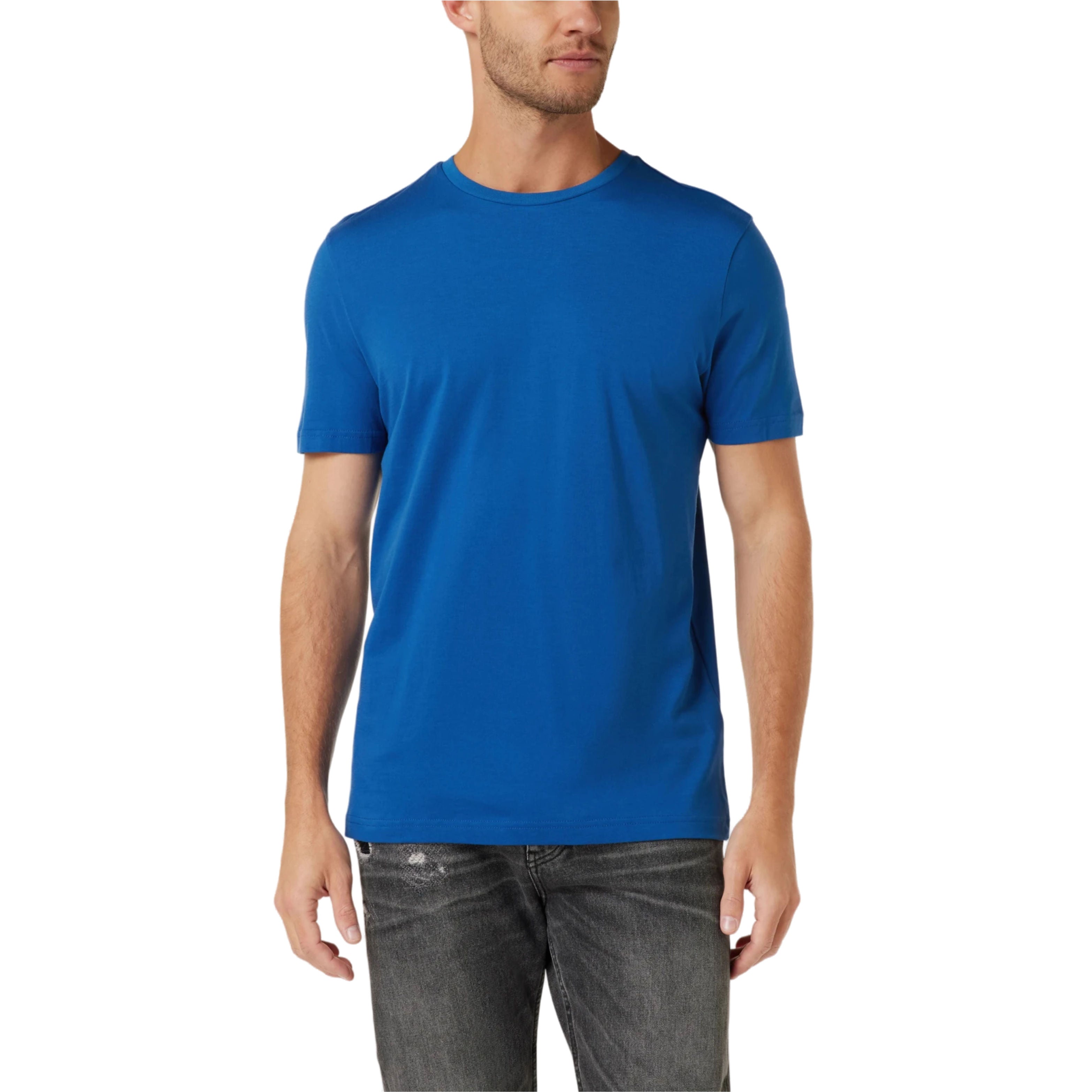 Man wearing a blue t-shirt and dark jeans on a white background